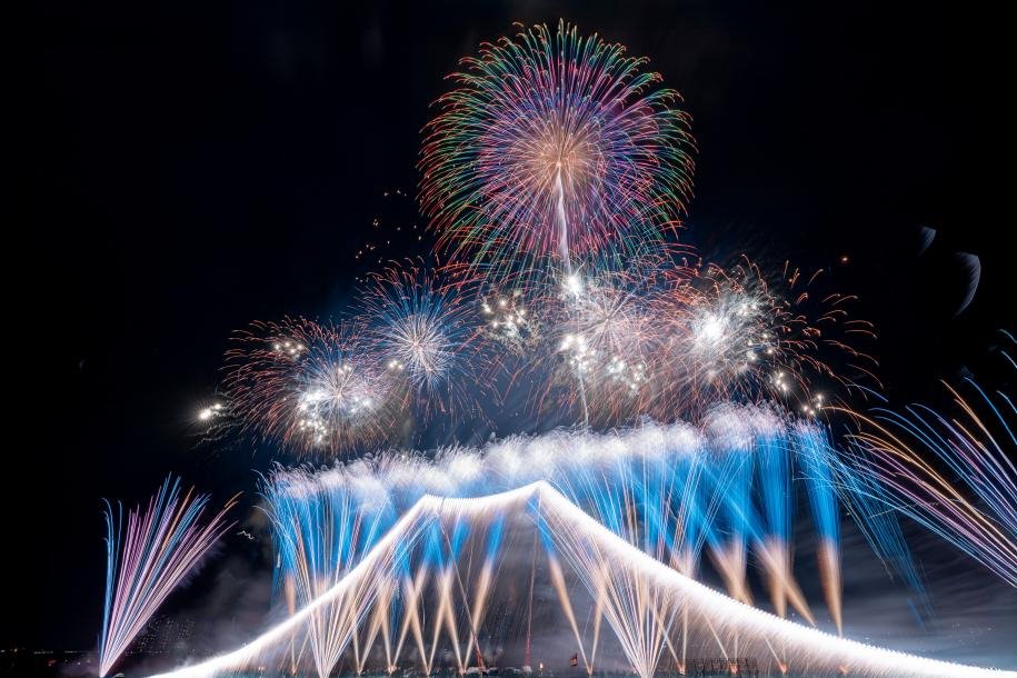 Japanese summer fireworks festival at Edogawa river in Tokyo, colorful hanabi bursting in the night sky
